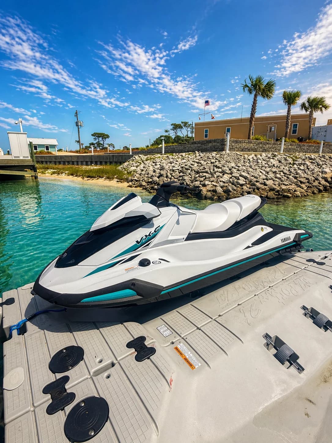 Riders on rental jet skis cruising calm Choctawhatchee Bay water with the Emerald Coast shoreline in the distance